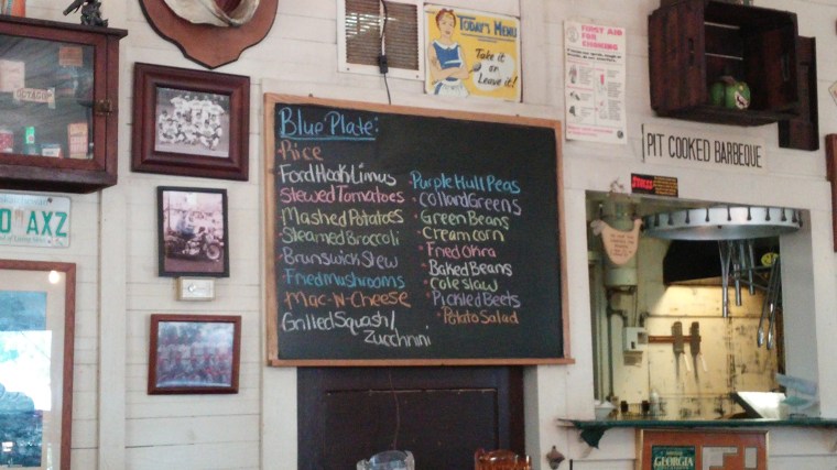 Southern side dishes are written in colorful chalk, hanging on a wall next to the kitchen.