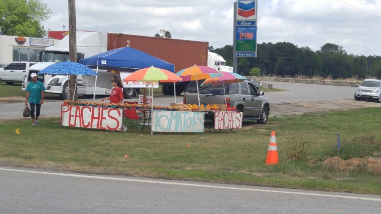A roadside stand sells fresh summer fruit.